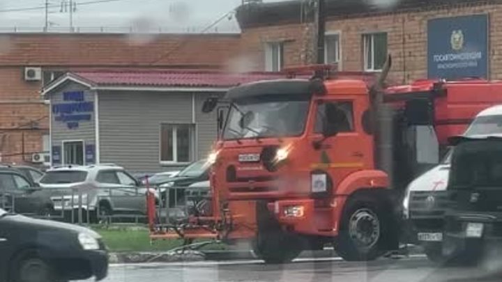 Коммунальщики моют дорогу в дождь