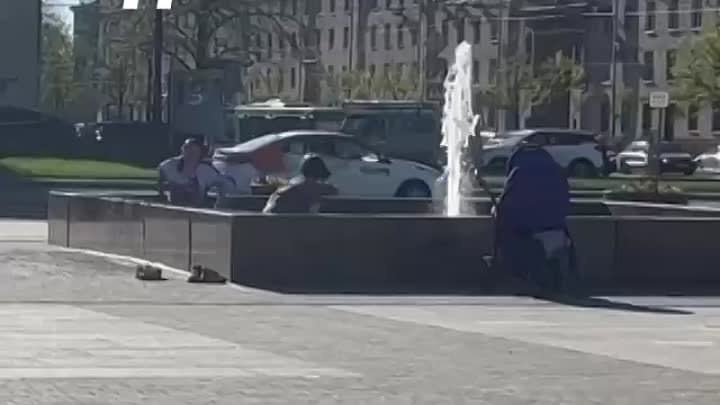 Люди купаются в фонтане.
