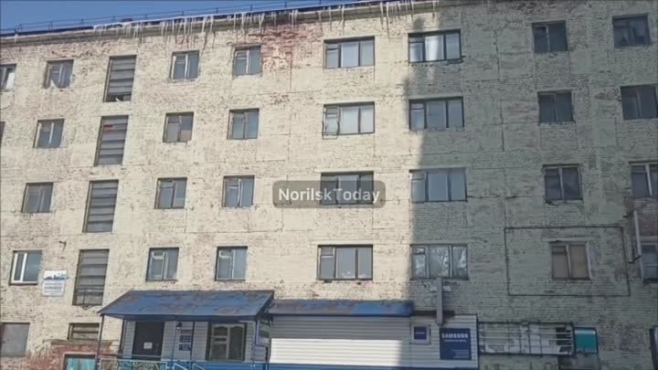 Огромные сосули свисают с крыши одного из домов в Норильске