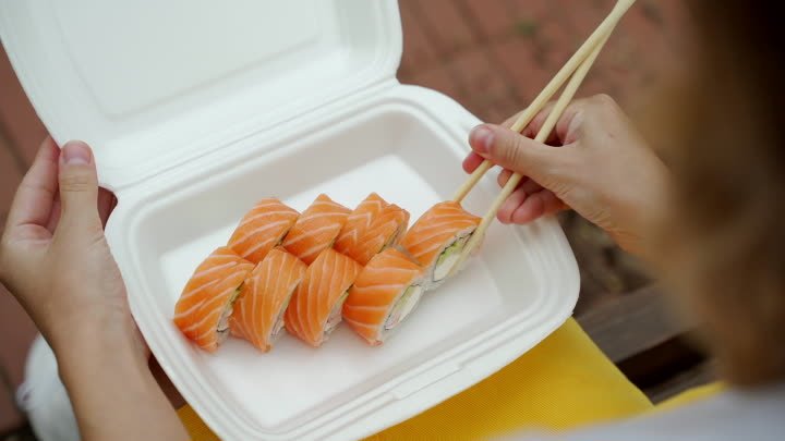 opens-the-package-with-rolls-and-sushi-and-hands-t-3M6QAMC