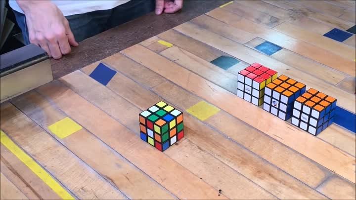 Механизм собирает кубик Рубика