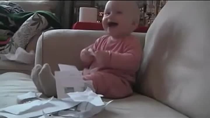 Ребёнок истерически смеётся над рвущейся бумагой