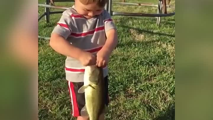 Маленький рыбак поймал рыбку на игрушечную удочку.