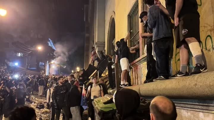 демонстранты закинули дымовую шашку в разбитое окно парламента Грузии